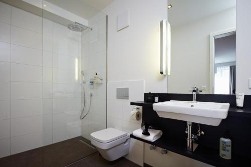 a bathroom with a sink and a toilet and a shower at ipartment Frankfurt Central Station in Frankfurt