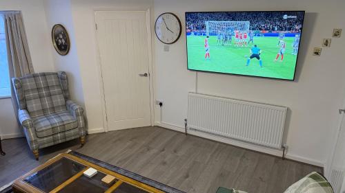 a living room with a flat screen tv on a wall at Peake Edge Home in Chesterfield