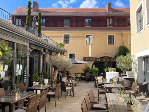 a patio with tables and chairs and a building at Herberge Zum Sechsten Gebot in Görlitz