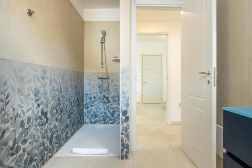 a bathroom with a shower with a blue and white tiles at Domus Soli in Teulada