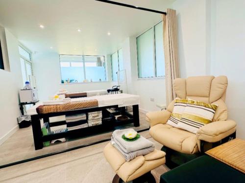 a living room with a chair and a mirror at Chalet 23 Widemouth Bay in Bude
