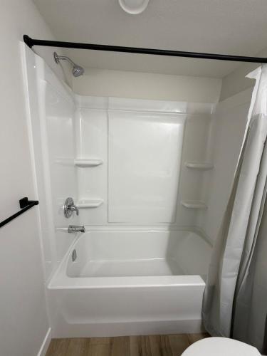 a white bathroom with a tub and a toilet at The Onyx Suite Sleek Modern Space Private Entry in Regina
