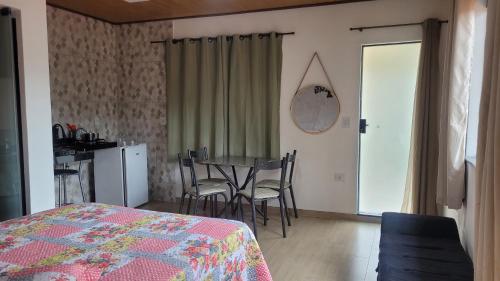 a bedroom with a bed and a table and chairs at Studio Mara Alagoa in Alagoa
