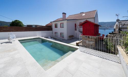 a swimming pool on the roof of a house at Apartamentos turísticos O Estaleiro in Moaña