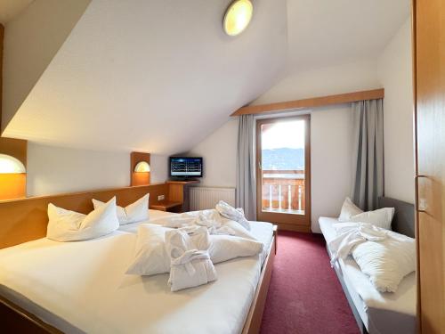 a hotel room with two beds and a window at Erlebnishotel Fendels in Fendels