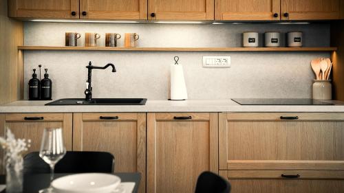 a kitchen with wooden cabinets and a sink and a table at Hiša 88 in Dutovlje