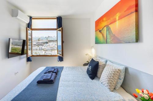 a bedroom with a bed and a large window at Modern Sea View Apartment Near Beach & Pool Puerto Rico in Puerto Rico de Gran Canaria