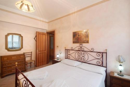 a bedroom with a large white bed and a dresser at Via Daneri 2 con giardino in Bonassola