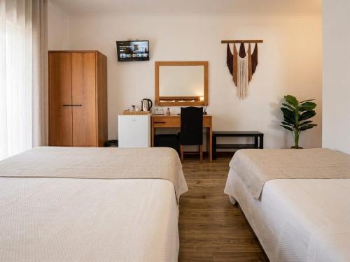 a room with two beds and a desk with a mirror at Verde Pinho in Geres