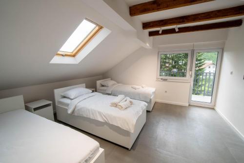 a bedroom with two beds and a window at Villa-Vista di Pini Sarajevo in Sarajevo