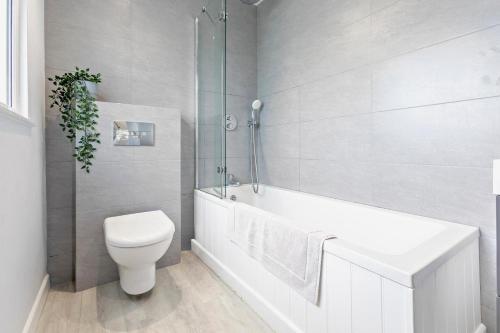 a bathroom with a toilet and a tub and a sink at 2 Bed in Croyde oc-18lead in Croyde