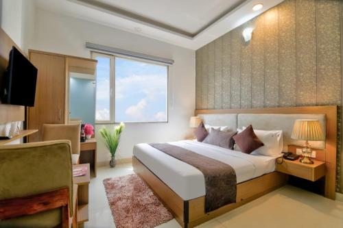 a bedroom with a large bed and a window at Hotel Olive Aero Suites By Signature Stayz Near Delhi Airport in New Delhi