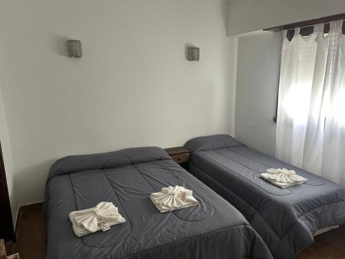 a bedroom with two beds with towels on them at Hanna in Mar del Plata
