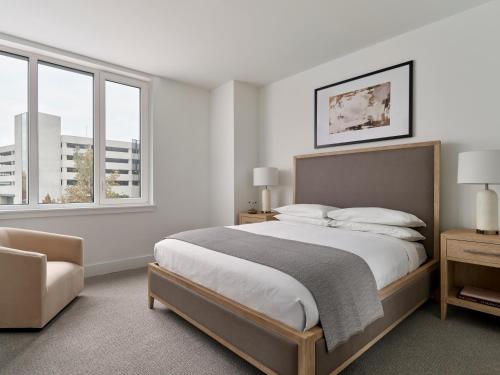 ein Schlafzimmer mit einem großen Bett und zwei Fenstern in der Unterkunft AVE Normandy - Extended Stay Furnished Apartment in Philadelphia