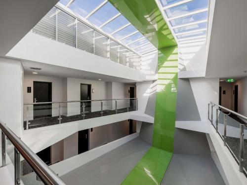 a hallway in a building with a green wall at Mercure Sydney St Leonards in Sydney