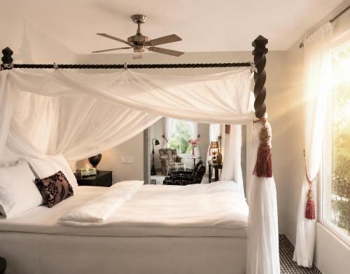 a white bed with a canopy in a bedroom at RoofTop Boutique Hotel Adults Only in Serekunda