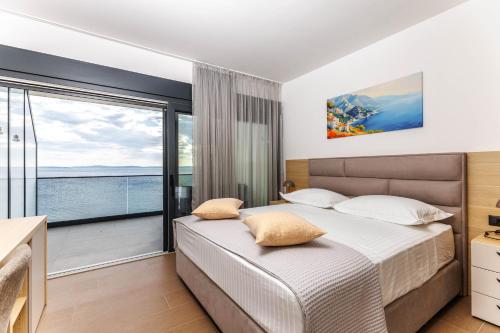 a bedroom with a bed and a large window at Stella Maris Beach in Podstrana
