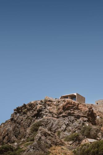 a building on top of a rocky mountain at The Revery, Elafonisi - Member of Leading Hotels of the World in Livadia