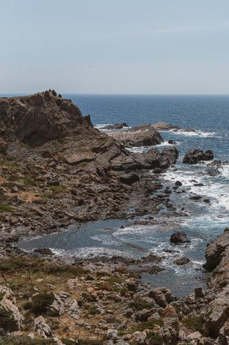 a rocky shore with the ocean in the background at The Revery, Elafonisi - Member of Leading Hotels of the World in Livadia