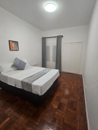 a bedroom with a bed and a wooden floor at Luxury Comfort House in Maputo
