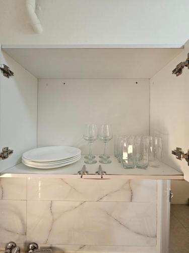 a cabinet with plates and glasses on top of it at Luxury Comfort House in Maputo
