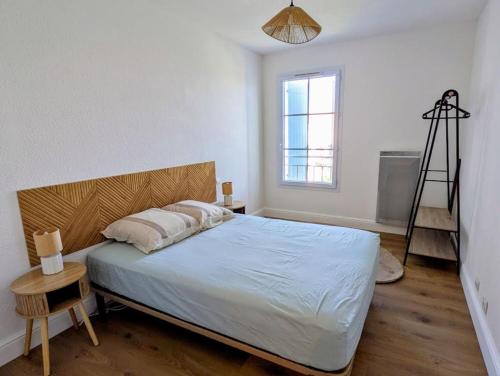 a bedroom with a bed with a wooden headboard and a ladder at Le cocon de Marennes in Marennes