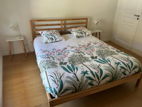 a bedroom with a bed with a floral bedspread at La Pistacherie à 30m de la plage de Grande Rive in Évian-les-Bains
