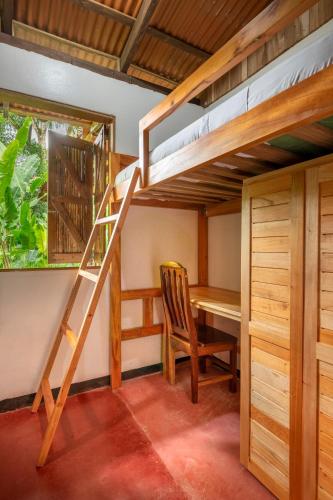 a room with a desk and a bunk bed at Rancho Margot Sustainable & Self Sufficient Eco Lodge in El Castillo de La Fortuna