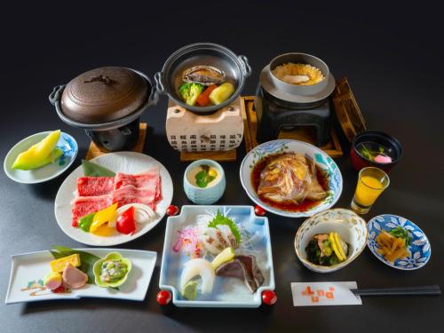 a table with plates of food and bowls of food at Hotel Luna Park in Matsuyama
