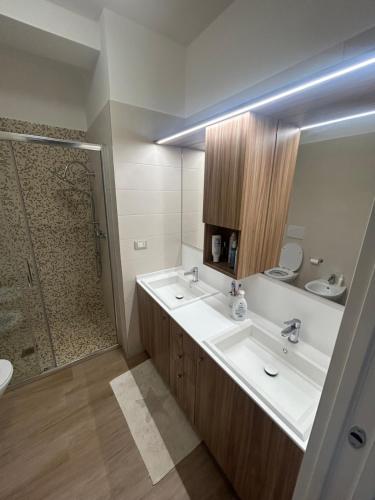 a bathroom with two sinks and a shower at Maiullari Holiday House in Policoro
