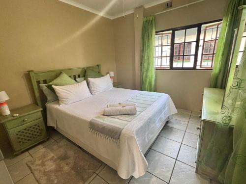 a bedroom with a bed with two towels on it at Siesta Island #5 in Amanzimtoti