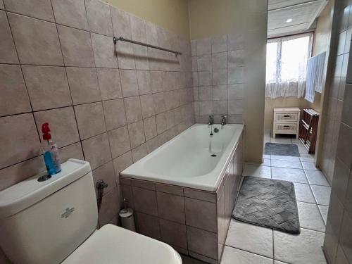 a bathroom with a white tub and a toilet at Siesta Island #5 in Amanzimtoti