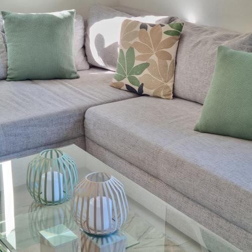 a couch with two glass vases on a glass table at Moderne Ferienwohnung,im fränkischen Seenland , 25 min Messe Nbg in Roth