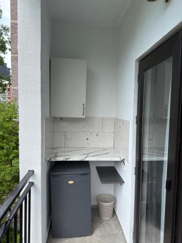 a white wall with a trash can next to a door at Hotel Palm Gonio in Kvariati