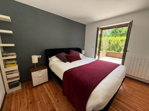a bedroom with a large bed and a sliding glass door at Courmayeur 2BR Terrace Mont Blanc View & Parking in Courmayeur