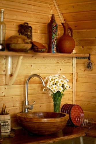 a kitchen counter with a sink and a vase of flowers at Shavsheti view Cottage in Didachara