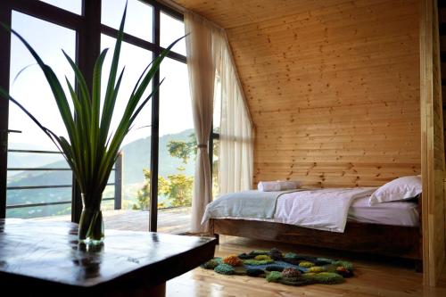 a bedroom with a bed and a large window at Shavsheti view Cottage in Didachara