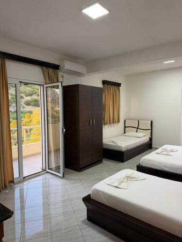 a hotel room with two beds and a balcony at Aria Apartments in Borsh
