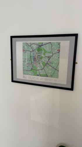 a picture hanging on a white wall with a picture at Hawtհorn Guestհouse in Cambridge