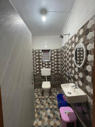 a bathroom with a toilet and a sink at ROGHAY COTTAGE in Matheran