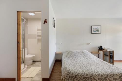 a bedroom with a bed and a bathroom at Chambres D'hôtes La Maison Rouge - in Contres