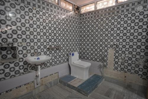 a bathroom with a toilet and a sink at Hotel Subarnrekha Heritage- Lalpur, Kanke Road in Rānchī