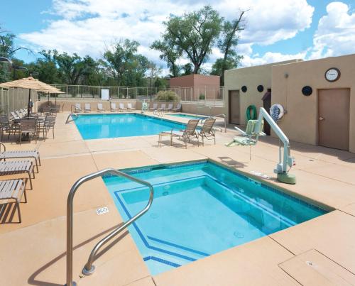 a swimming pool with tables and chairs next to a building at CW Taos Resort Two 1BR Suites in Taos