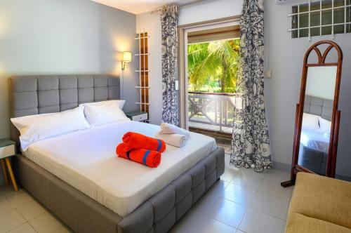a bedroom with a bed with a red stuffed animal on it at Beachfront Duplex with Estate Pool in Bain Boeuf