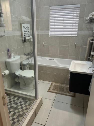 a bathroom with a toilet and a tub and a sink at Bonne Esperance in Tyger Valley