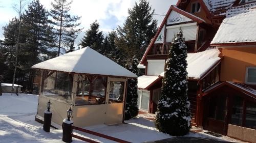 a snow covered building with a snow covered porch at Apartment Velago in Zlatibor