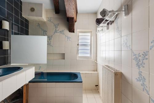 a bathroom with a blue sink and white tiles at Coeur de Ville - Beaugency in Beaugency