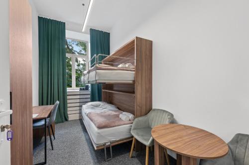 a room with a bunk bed and a table and chairs at ZDZ Hostel Królewska 15 in Lublin
