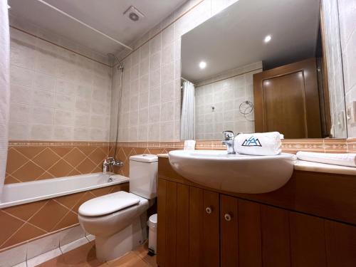 a bathroom with a sink and a toilet and a mirror at AC Apartaments Comapedrosa Canillo in Canillo