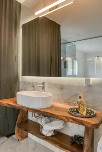 a bathroom with a sink and a mirror at Sahara Blanc Villa - Private Pool - Loft Space in Spiliazéza